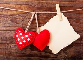 Blank sheet, a note, a torn sheet of paper and vintage red hearts hanging on garland. Valentines day concept photo