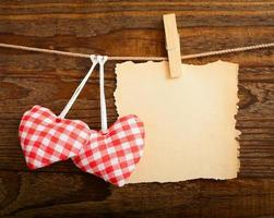 Blank sheet, a note, a torn sheet of paper and vintage red hearts hanging on garland. Valentines day concept photo