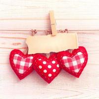 Blank sheet, a note, a torn sheet of paper and vintage red hearts hanging on garland. Valentines day concept photo