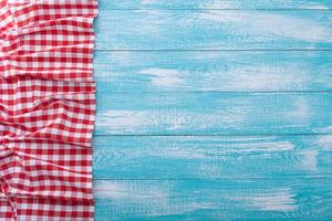 Wooden table covered with tablecloth cloth checkered red. photo