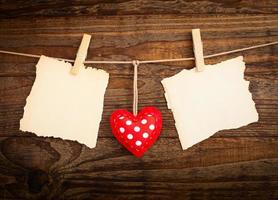 Blank sheet, a note, a torn sheet of paper and vintage red hearts hanging on garland. Valentines day concept photo