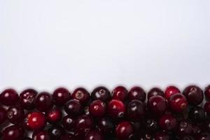 Background of ripe red cranberry berries and white space for copying, top view of cranberry berries photo