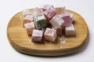 Sweet delicious colored lukum, Turkish delight with powdered sugar on a white background. photo