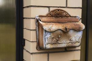 Mailbox of a private house, a mailbox made of black metal installed on a brick fence of a private residential house photo