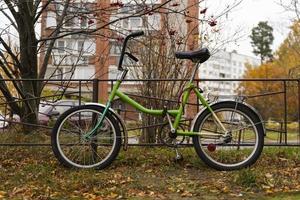 una vieja bicicleta de ciudad estacionada en la ciudad, ir en bicicleta al trabajo, andar en bicicleta en un entorno urbano foto