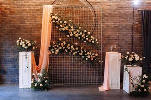 Wedding decor. Photographic area is a stylish wedding decoration. Decorated with flowers, mini florals. Wedding photo zone with flowers. Hand made wedding decorations. Place for taking pictures