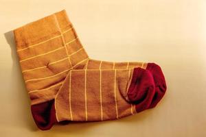 Brown socks with yellow stripes. New socks on a beige background. photo
