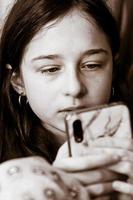 Teenage girl shoulder looking into smartphone. Black and white photos of a sad girl.