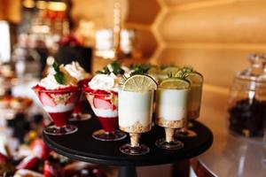 luxury wedding catering, table with modern desserts, cupcakes, sweets with fruits. delicious candy bar at expensive wedding reception. party holiday celebration. selective focus
