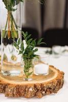 Table setting at wedding reception. Floral compositions with flowers and greenery, candles on decorated table. Coziness and style. Modern event design. selective focus. photo