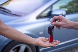 The car salesman and the key to the new owner. photo