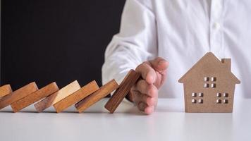 el seguro con las manos protege una casa. seguro de hogar o concepto de seguro de hogar