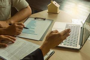 Businessmen are describing investment plans to investors through graph papers and computers photo