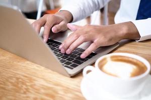 The human hand uses the keyboard by the notebook on the desk. Internet education and communication concepts photo