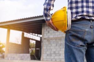 ingenieros o contratistas que trabajan en obras de construcción en la mano con casco. conceptos de ingeniería y arquitectura foto