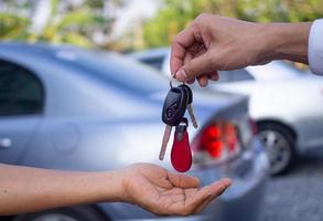 The car salesman and the key to the new owner. photo