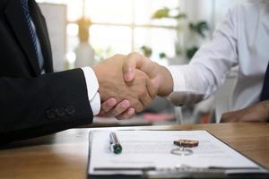 Businessmen handshake to invest and share profits in building and residential projects. Have a contract document that has legal effect photo