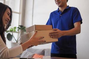 Woman accepting on line shopping  product  from  home delivery man. Service concept, Quick and convenient. Stay home and Buy products online. photo