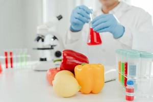 el científico comprueba los residuos de alimentos químicos en el laboratorio. expertos en control inspeccionan la calidad de frutas, verduras. laboratorio, peligros, rohs, encontrar sustancias prohibidas, contaminar, microscopio, microbiólogo foto