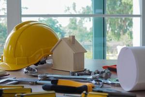 Tools and equipment used in construction. Placed on the desk ,Hard hat construction plans on wooden board building concept. photo