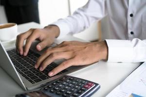 The human hand uses the keyboard by the notebook on the desk. Internet education and communication concepts photo