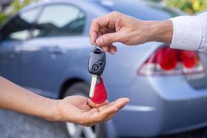 The car salesman and the key to the new owner. photo