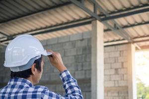 el contratista se quedó mirando el sitio de construcción o el edificio que actualmente se está renovando o modificando. comprobar la preparación de la construcción. foto