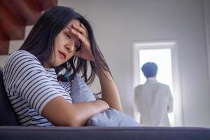las mujeres asiáticas están estresadas, sentadas preocupadas por problemas familiares, desgarradoras y con síntomas mentales. foto