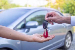 el vendedor de autos y la llave del nuevo dueño. foto