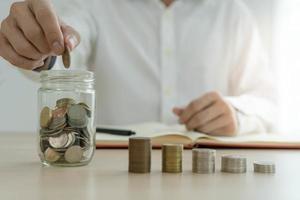 Businessman holding a coin in a piggy bank. Money saving , financial accounting, income and investment concept. photo