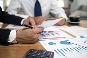 Businessmen together brainstorm ideas for calculating statistical data of investment budgets, making new projects. photo