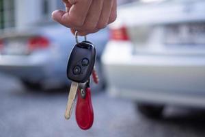 The car salesman and the key to the new owner. photo