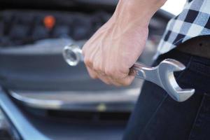 Car mechanic hand with a car repair wrench. photo