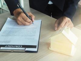 Man hand signing house lease contract photo