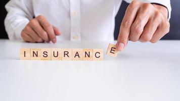 Insurance concept Hand wooden arrangement on wood background photo