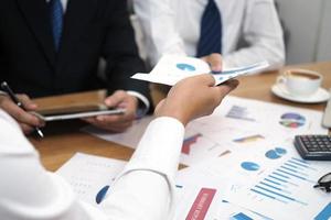 Brainstorming stock market investment plans. With statistical data showing profits and income. teamwork concept photo