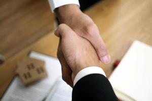 Businessmen handshake to invest and share profits in building and residential projects. Have a contract document that has legal effect photo