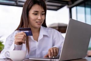 Close up female hands holding credit card and smartphone. Woman paying online,using banking service, entering information, Pay bills ,shopping concept.