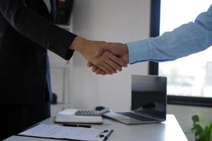 Two businessmen shake hands after negotiating the agreement and signing the contract. photo