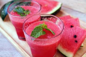 Fresh watermelon juice is in a glass and sliced watermelon on the plate. photo