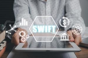 swift, sociedad de telecomunicaciones financieras interbancarias en todo el mundo, persona de negocios que usa tableta con pantalla vr icono de swift en el escritorio de la oficina, concepto de regulación de la banca financiera. foto