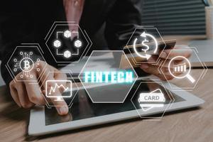 inversión en criptomonedas de tecnología financiera fintech y dinero digital, persona de negocios que usa una tableta en el escritorio de la oficina con un icono fintech en la pantalla vr. foto