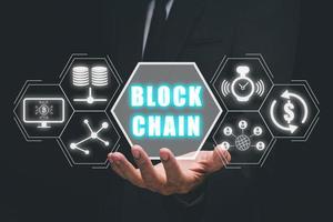 Blockchain technology concept, Businessman hand holding blockchain icon on virtual screen, Fintech concept with encrypted ledger blocks chained. photo