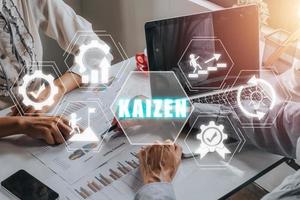 concepto kaizen, equipo de personas de negocios que trabaja en una computadora portátil y analiza datos financieros con un ícono kaizen en la pantalla virtual, filosofía empresarial y concepto de estrategia corporativa de mejora continua. foto