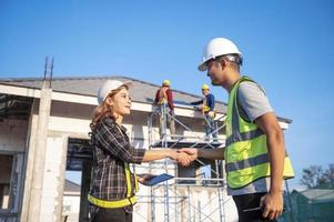 Construction inspector and female architect discuss with chief engineer Asia about installing solar panels on a construction project. Visit the construction site to install solar panels. photo