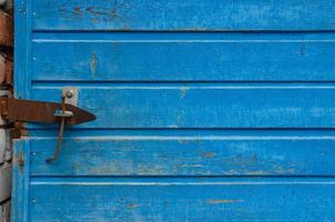 the door is closed with a nail, the background is blue wooden photo