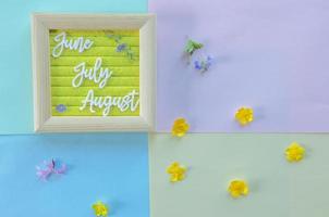 layout on a colored background of the summer months with flowers photo