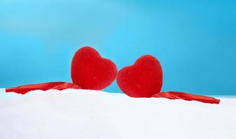 Two red hearts side by side in the snow. Saint Valentine's day, love. Copy space photo