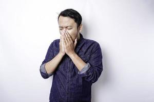 A portrait of an Asian man wearing a blue shirt isolated by white background looks depressed photo