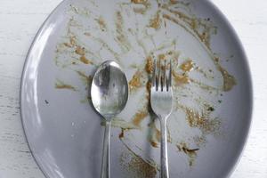 Top view of dirty dishes with sauce smeared on a plate isolated on white background photo